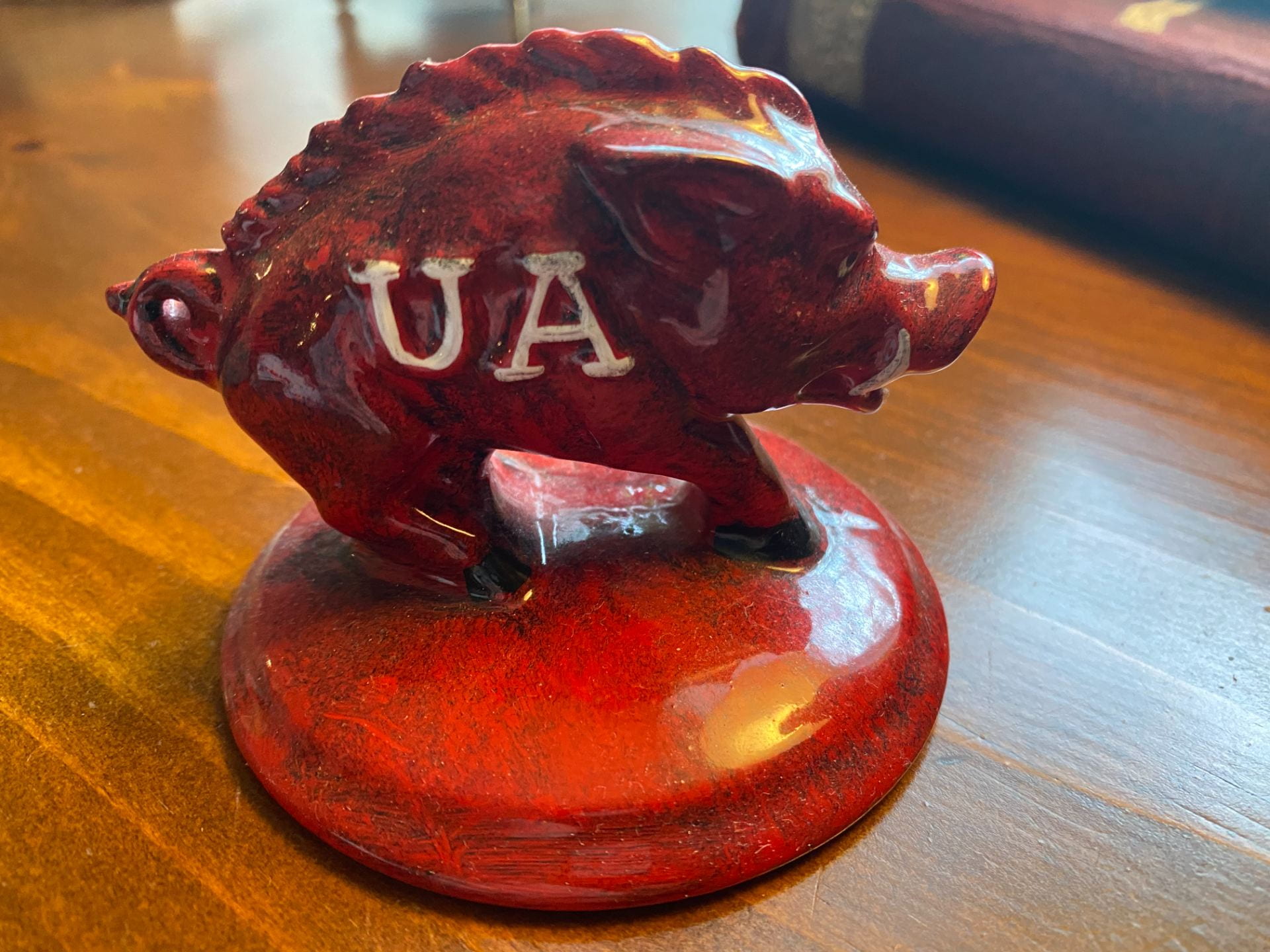 A ceramic red paperweight Razorback with "UA" on its side