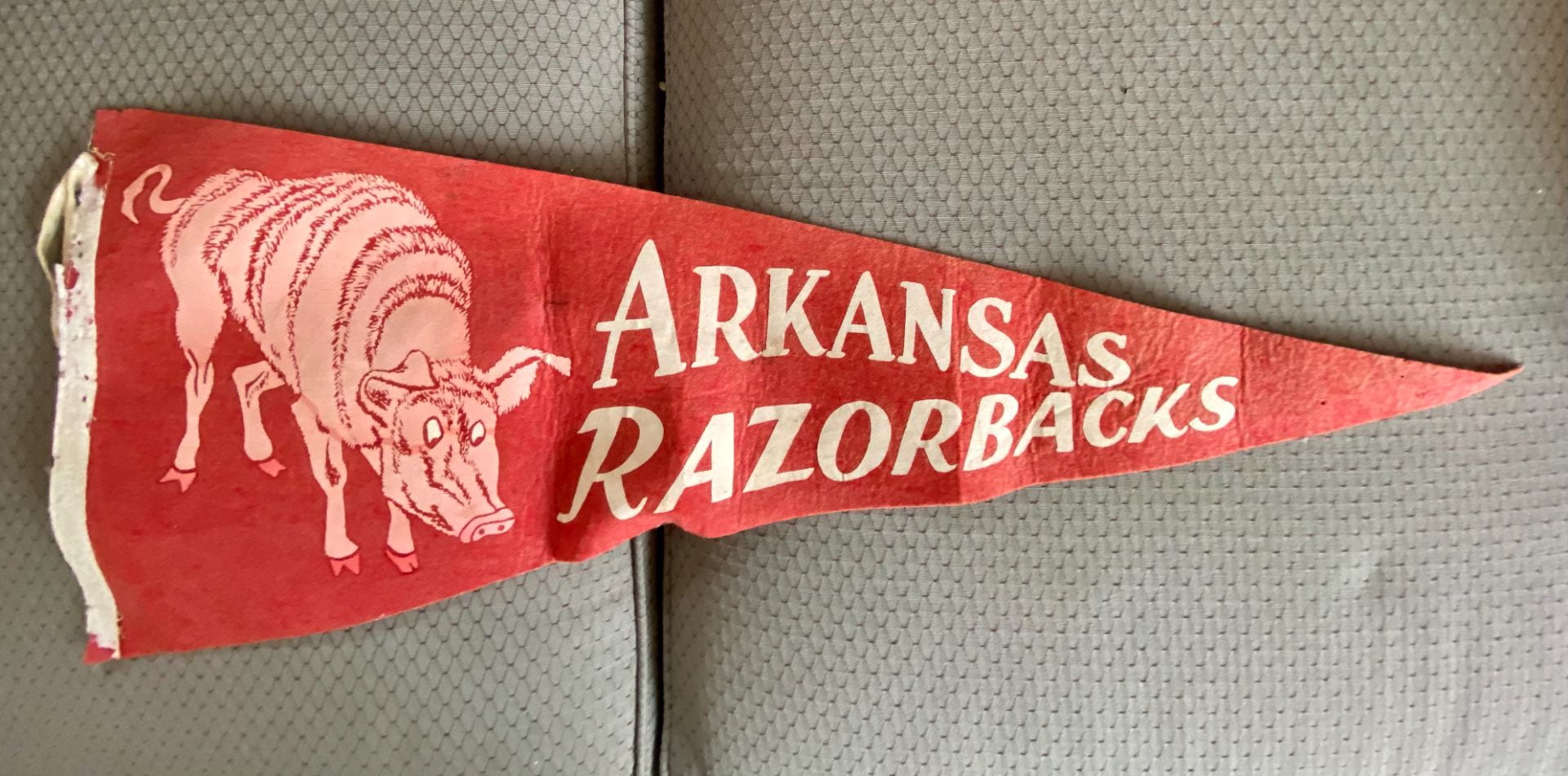 A red pennant with a pig illustration on the widest part and "Arkansas Razorbacks" to its right.