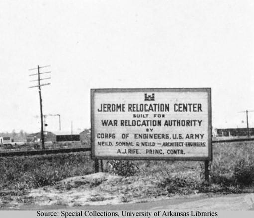 A large sign outside with vegetation and telephone pole behind it. The sign says "Jerome Relocation Center built for War Relocation Authority by Corps of Engineers, U.S. Army"