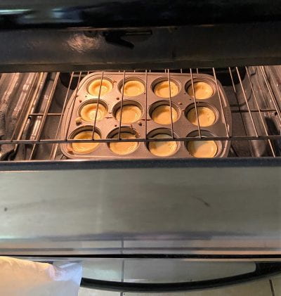 Oven open with yorkshire pudding baking