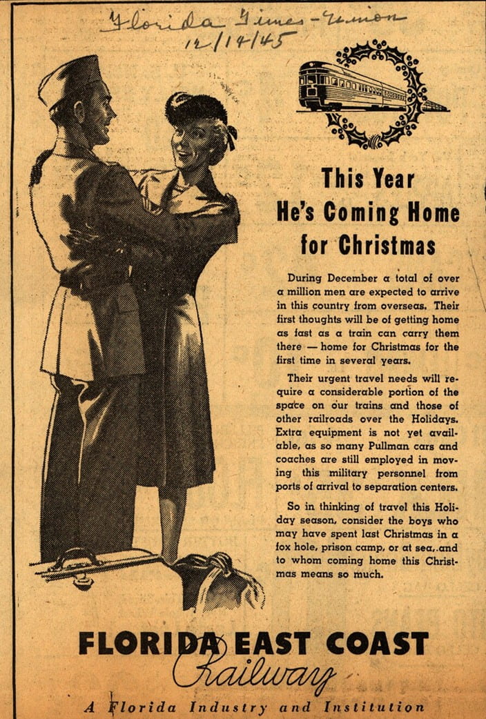 A black and white advertisement with a man in military uniform embracing a woman and bags at their feet. A small train is above and to their right. The ad says "This year he's coming home for Christmas"