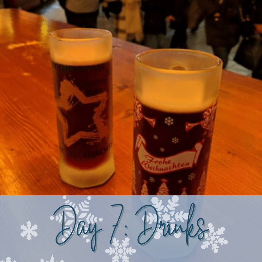 Two glasses filled with brown liquid and a blue banner at the bottom of the image that says "Day 7: Drinks."
