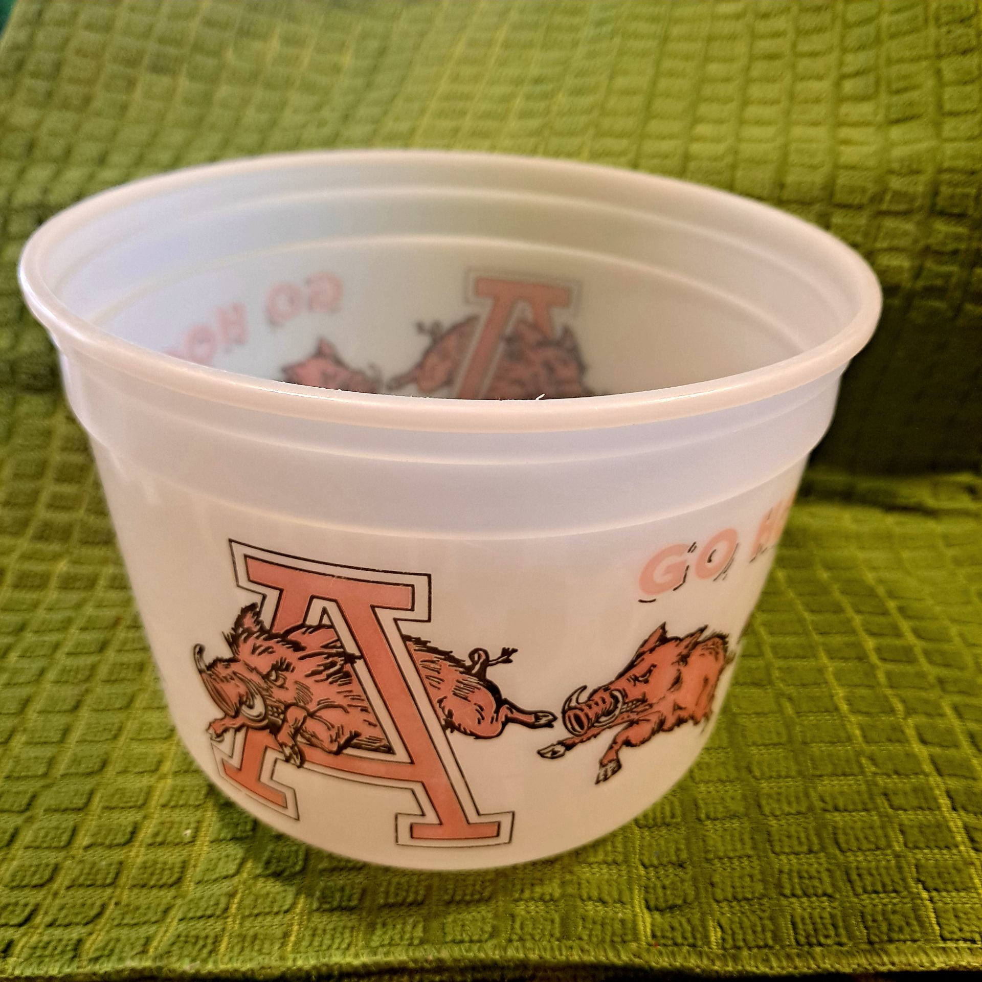 A plastic popcorn container with a Razorback running through a large red "A."
