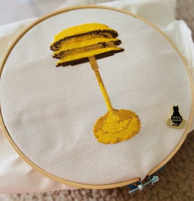 Image of the cross stitch project - shows a yellow lamp