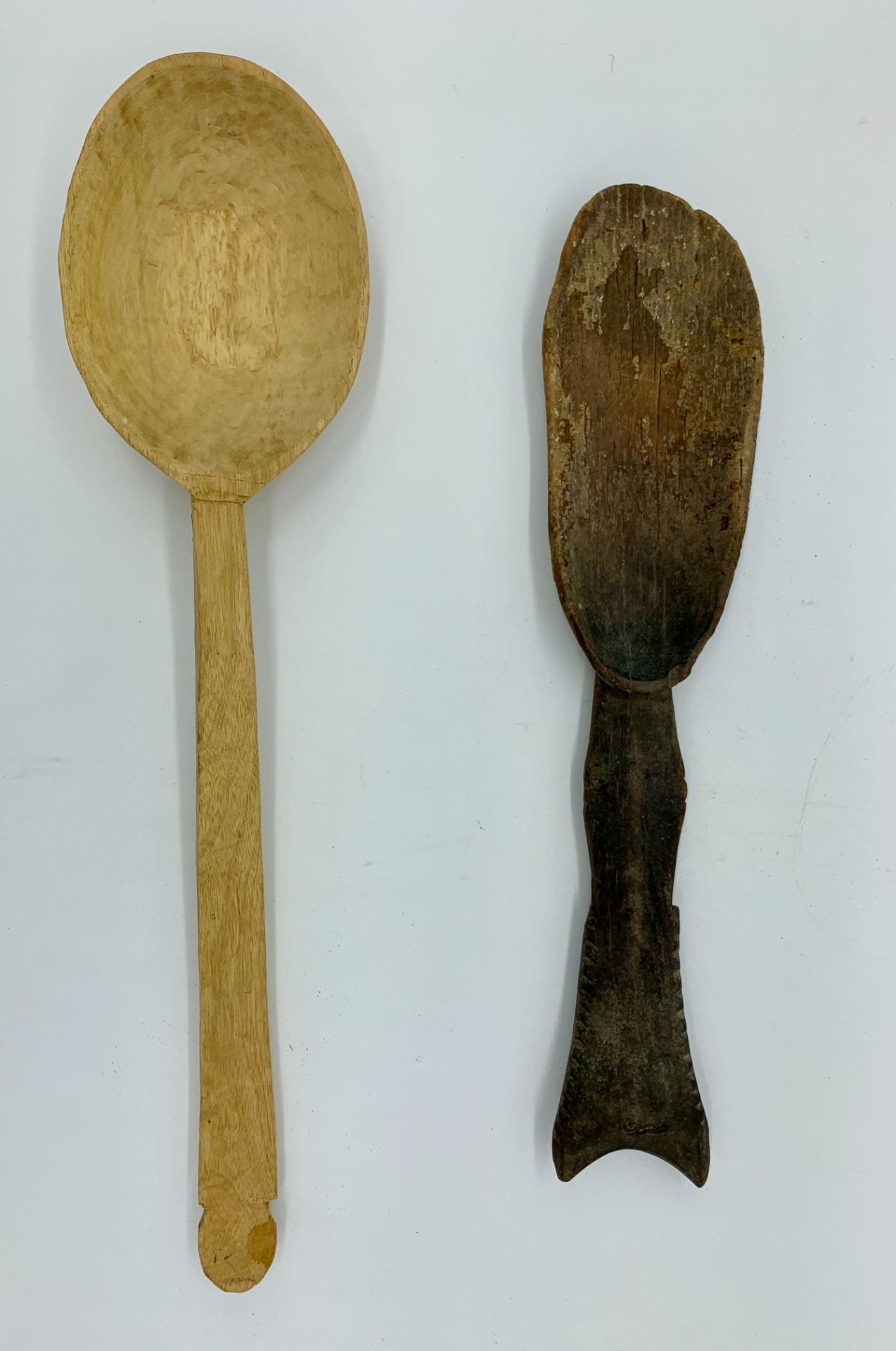 Two wooden spoons laid out on a white surface.